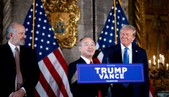 PALM BEACH, FLORIDA - DECEMBER 16: SoftBank CEO Masayoshi Son (C), accompanied by U.S. President-elect Donald Trump (R) and Trump's choice for Secretary of Commerce, Cantor Fitzgerald Chairman and CEO Howard Lutnick (L), speaks at a news conference at Trump's Mar-a-Lago resort on December 16, 2024 in Palm Beach, Florida. In a news conference that went over an hour, Trump announced that SoftBank will invest over $100 billion in projects in the United States including 100,000 artificial intelligence related jobs and then took questions on Syria, Israel, Ukraine, the economy, cabinet picks, and many other topics.   Andrew Harnik/Getty Images/AFP (Photo by Andrew Harnik / GETTY IMAGES NORTH AMERICA / Getty Images via AFP)