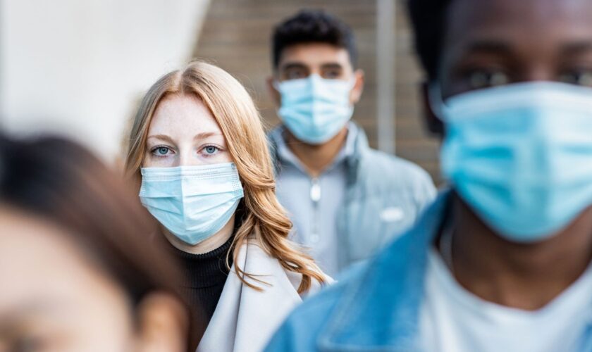 Authentic shot of multiracial people in the city wearing face mask and walking on the pavement commuting to work - Lifestyle and health issues concepts