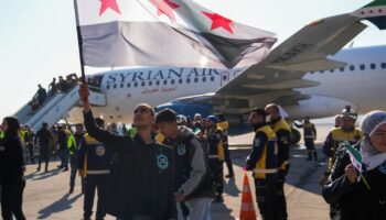 Des passager descendent d'un avion en provenance de Damas, le premier depuis la chute de Bachar al-Assad, à leur arrivée à l'aéroport d'Alep, le 18 décembre 2024 en Syrie