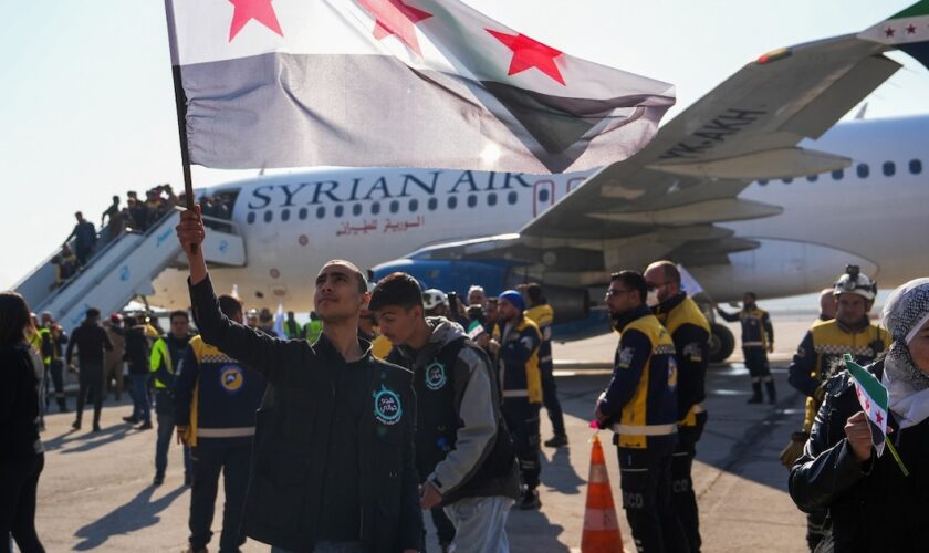 Des passager descendent d'un avion en provenance de Damas, le premier depuis la chute de Bachar al-Assad, à leur arrivée à l'aéroport d'Alep, le 18 décembre 2024 en Syrie