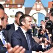 Le président français Emmanuel Macron (C), avec l'officier supérieur de sécurité de l'Élysée Alexandre Benalla (G), serre la main des gens après avoir voté au Touquet, lors du second tour des élections législatives françaises, le 18 juin 2017.