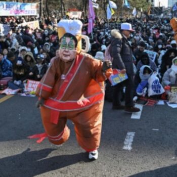 Tanzender Demonstrant mit Yoon-Maske