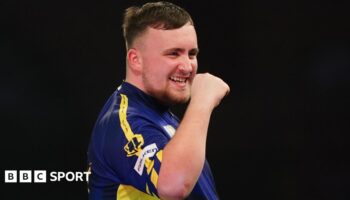 Luke Littler celebrates winning a leg against Ian White in the third round of the PDC World Darts Championship