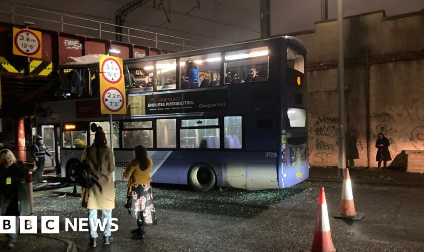 Roof torn off bus after railway bridge crash