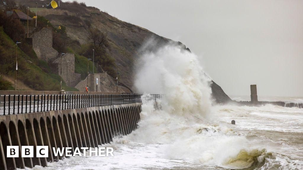 A waves crashing over a sea defence promenade during a storm