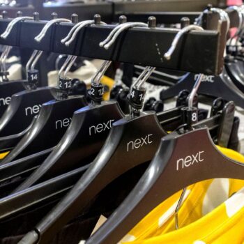 Garments on coat hangers are pictured at a store of clothing retailer Next, in London, Britain, November 17, 2021. Picture taken November 17, 2021. REUTERS/May James