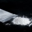 ketamine drugs and plastic straw on bag of white powder on black wood background.Drug epidemic concept.