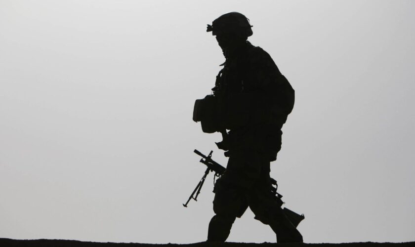 A British soldier is silhouetted as he walks with his machine gun on a roof top of a residential house in the village Qari Sahib, Nad Ali district, Helmend province, southern Afghanistan, Monday, Feb. 15, 2010 (AP Photo/Altaf Qadri)