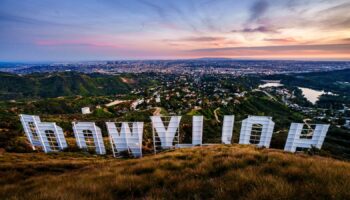 Sunset casts a pink glow over the Los Angeles skyline as seen from behind the famous Hollywood sign Wednesday evening, March 8, 2023. The 95th annual Academy Awards will be held Sunday at the Dolby Theatre in the Hollywood section of Los Angeles. (AP Photo/J. David Ake)