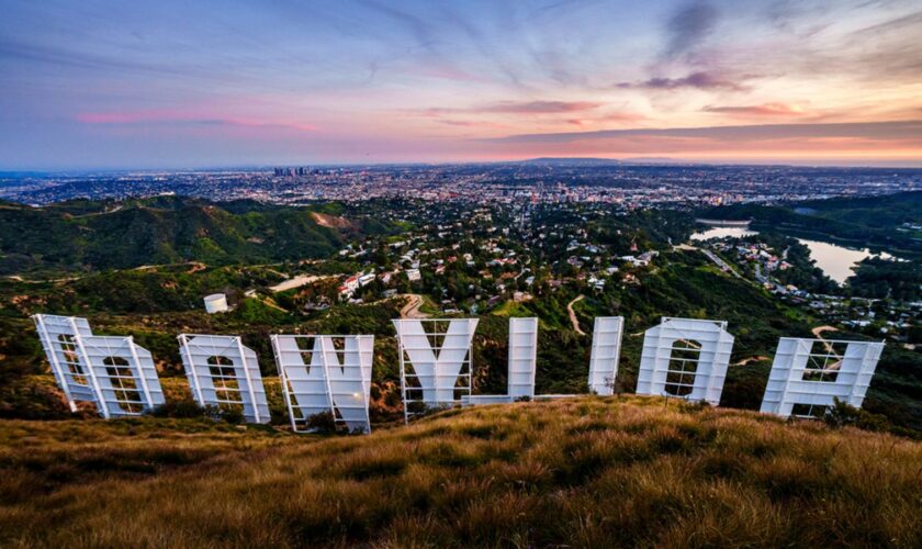 Sunset casts a pink glow over the Los Angeles skyline as seen from behind the famous Hollywood sign Wednesday evening, March 8, 2023. The 95th annual Academy Awards will be held Sunday at the Dolby Theatre in the Hollywood section of Los Angeles. (AP Photo/J. David Ake)