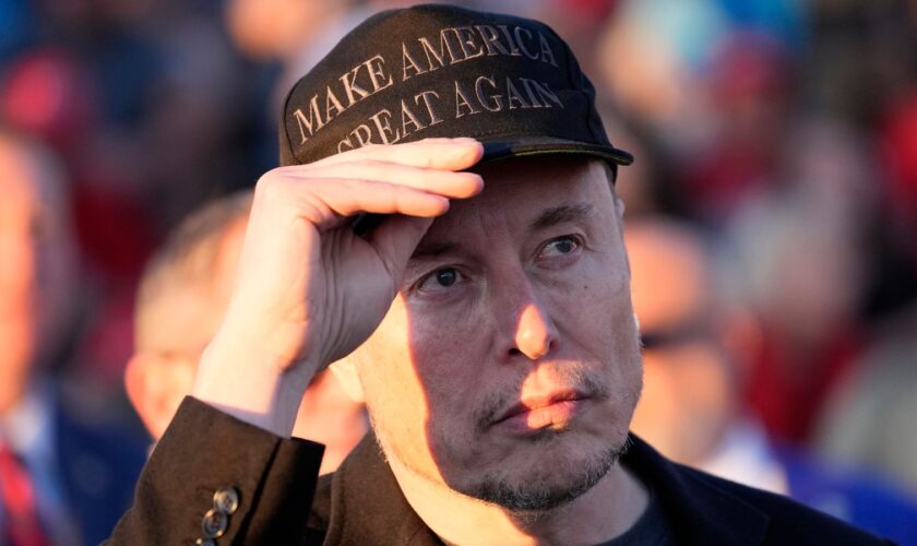 FILE - Tesla and SpaceX CEO Elon Musk listens as Republican presidential nominee former President Donald Trump speaks at a campaign event at the Butler Farm Show, on Oct. 5, 2024, in Butler, Pa. (AP Photo/Alex Brandon, File)