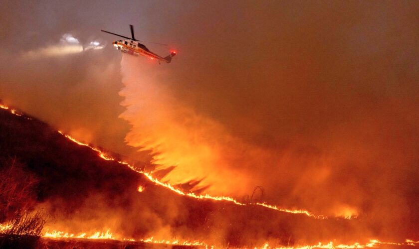 Water is dropped by helicopter on the Kenneth Fire in the West Hills section of Los Angeles, Thursday, Jan. 9, 2025. (AP Photo/Ethan Swope)