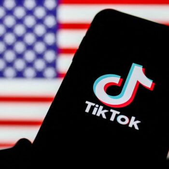 TikTok logo is seen displayed on a phone screen with American flag in the background in this illustration photo taken on August 2, 2020. President of the USA Donald Trump said that Chinese app TikTok will be banned in the United States. (Photo Illustration by Jakub Porzycki/NurPhoto) (Photo by Jakub Porzycki / NurPhoto / NurPhoto via AFP)