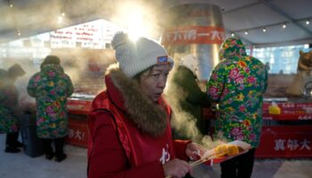 AP PHOTOS: Warm clothing, hot pot and even ice cream bars feature at China's Harbin ice fair