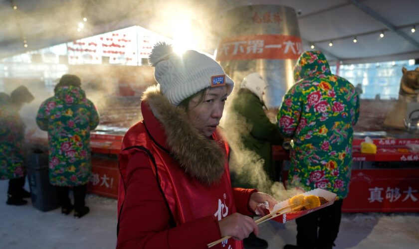 AP PHOTOS: Warm clothing, hot pot and even ice cream bars feature at China's Harbin ice fair