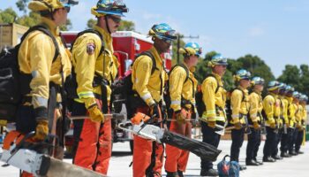 CAMARILLO, CALIFORNIA - JULY 14: Cadets, who were formerly incarcerated, stand with wildland firefighting equipment at the Ventura Training Center (VTC) during an open house demonstration for media and prospective participants on July 14, 2022 in Camarillo, California. The program was developed in 2018 to take formerly incarcerated people, who previously battled fires as California Department of Corrections and Rehabilitation (CDCR) inmate camp members, and train them for a career as professional firefighters. As climate change has stoked increased wildfire behavior in California, there is a surge in demand for trained wildland firefighters across the state. Participants are carefully screened before being accepted to the free 18-month program where they receive a monthly stipend, health insurance, life coaching and mentorship in an effort to reduce recidivism.   Mario Tama/Getty Images/AFP (Photo by MARIO TAMA / GETTY IMAGES NORTH AMERICA / Getty Images via AFP)