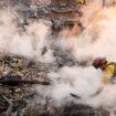 A firefighter clears away smoking debris at the site of building in Altadena. Pic: AP Photo/Chris Pizzello