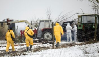 Staff in PPE with rifles at a farm in Hoppegarten, east of Berlin. Pic: AP