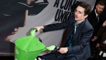 Timothee Chalamet rides an electronic bicycle upon arrival at the premiere of the film 'A Complete Unknown' in London, on Tuesday, Jan. 14, 2025. (Photo by Scott A Garfitt/Invision/AP)