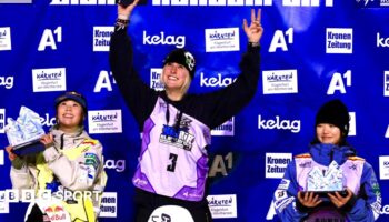 Mia Brookes lifts her trophy on the podium after winning the big air World Cup event in Klagenfurt