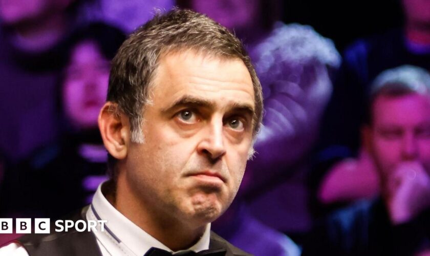 Ronnie O'Sullivan looks at a snooker table