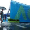 Fans arrive at Melbourne Park under an umbrella