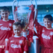 Accrington Stanley forward Josh Woods (front) aged five in his Liverpool kit with the 2005 Champions League trophy with his brothers Connor (right) and Dale (left)