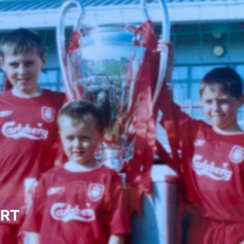 Accrington Stanley forward Josh Woods (front) aged five in his Liverpool kit with the 2005 Champions League trophy with his brothers Connor (right) and Dale (left)