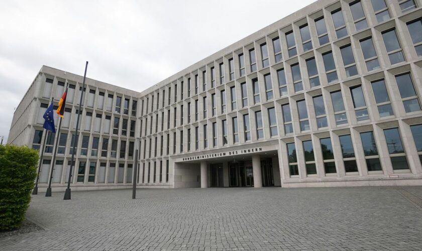 Brenzlige Lage am Innenministerium: Ein Pflasterstein fliegt im Eingangsbereich. (Archivbild) Foto: Jörg Carstensen/dpa